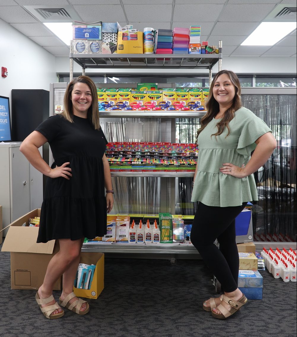 TVS HR representatives stand beside the organized school supply donations.